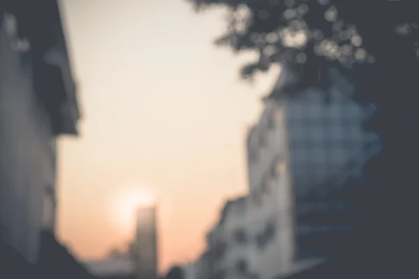 Arka plan bulanık, şehirde bina arasında günbatımı — Stok fotoğraf