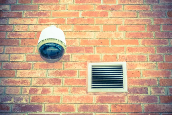 Security camera on orange brick wall — Stock Photo, Image