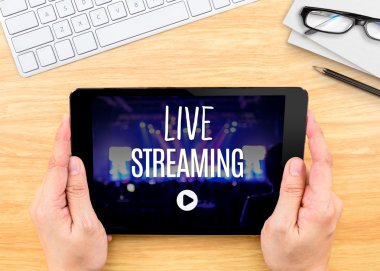Hands holding tablet with Live Streaming  clipart