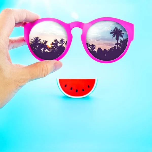 Hand som håller sommaren rosa glasögon — Stockfoto