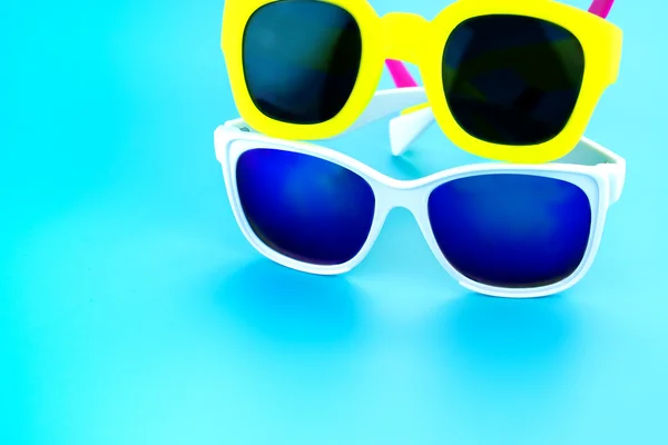 Gafas de sol de colores en estudio azul claro — Foto de Stock