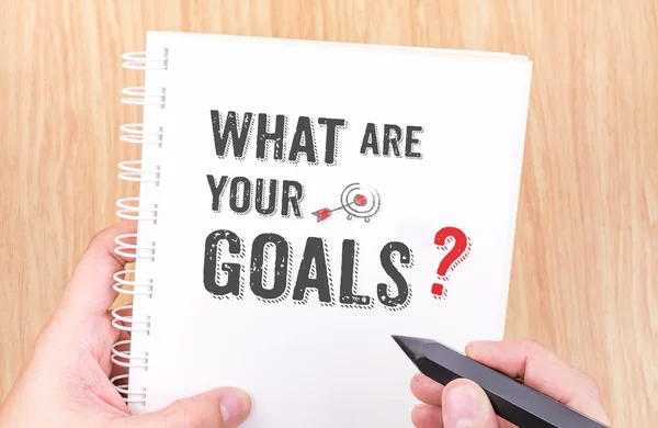 What are your goal? word on white ring binder notebook with hand