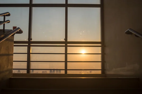 Olhando para cima ao pôr do sol na janela no prédio de escritórios — Fotografia de Stock