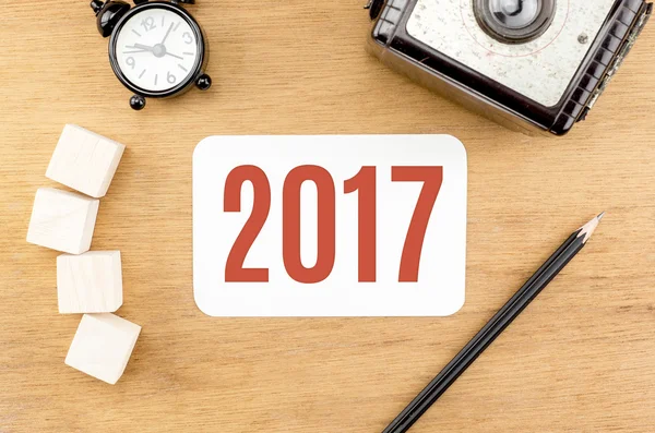 Kırmızı 2017 yeni yıl numarası ile kağıt kartı, ahşap masa üst ala — Stok fotoğraf