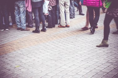 binanın önünde kaldırımda yürüyen insanlar