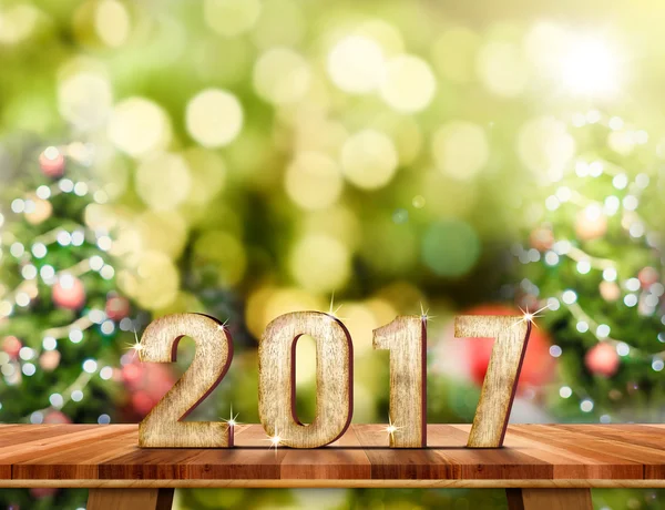 Número de Año Nuevo 2017 en la mesa Brown Wood con desenfoque abstracto — Foto de Stock