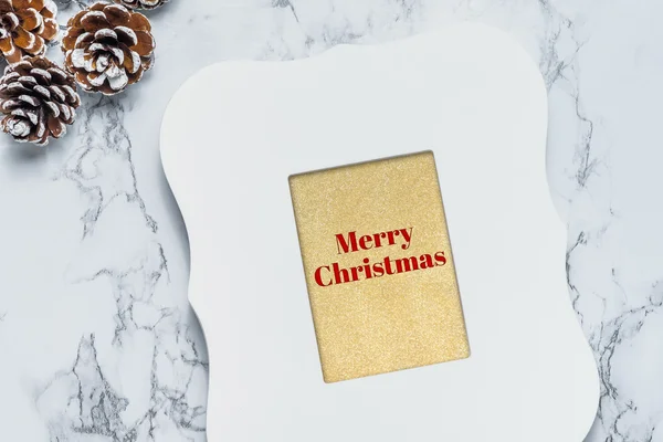 Merry christmas text in vintage white picture frame with pine co — Stock Photo, Image