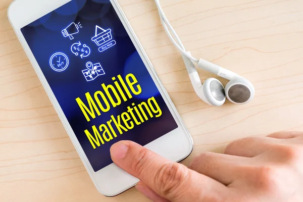 Mano toccare smart phone e auricolare con parola Mobile marketing — Foto Stock