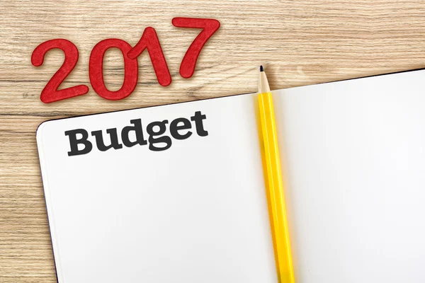 Ovanifrån av 2017 nyår röda nummer med budget öppna anteckningsboken en — Stockfoto