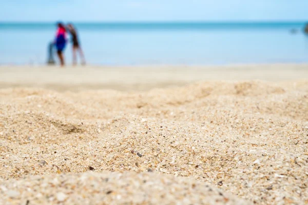 Zbliżenie piasek z plaży morze rozmycie i ludzi, niskie anagle — Zdjęcie stockowe