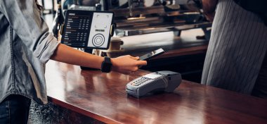 Kafe tezgahında cep telefonuyla içki için müşteriye ulaşılamayan ödemeler, satıcı kahve dükkanı mobiletle ödeme yapmayı kabul ediyor. Yeni normal yaşam tarzı kavramı