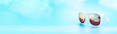 summer palm tree sunset reflection on sunglasses with blue sky and sea.banner background for display of product or text promotion