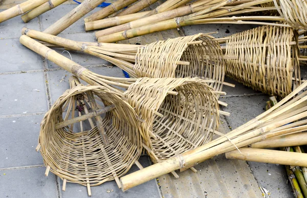 Cesta de mimbre de bambú en el suelo cerca del suelo negro —  Fotos de Stock