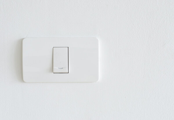 Lighting switch on white wall