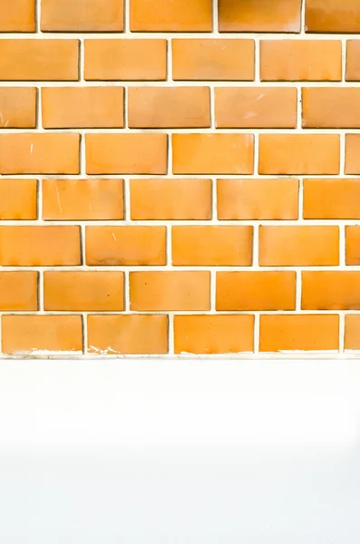 Orangefarbene Ziegelmauer mit weißer Zementbemalung an Wand und Pflaster — Stockfoto