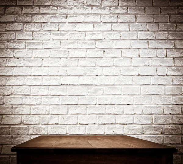 Bakstenen muur en houten tafel — Stockfoto