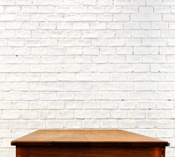 Кирпичная стена и деревянный стол — стоковое фото