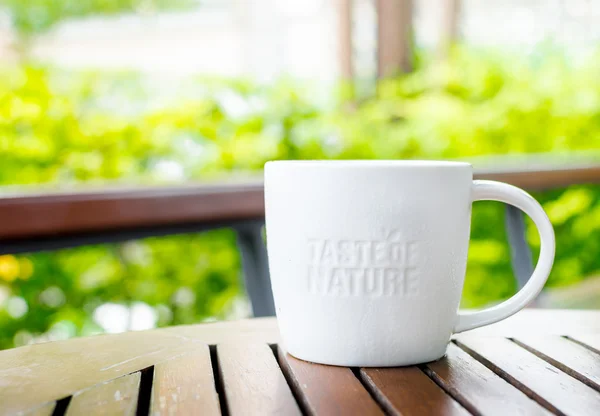 Taza de cerámica blanca con palabra de sello "Sabor de la naturaleza" en el café sh — Foto de Stock