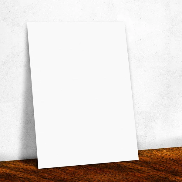 Leeres weißes Papier an der weißen Wand und auf dem Holzboden, — Stockfoto