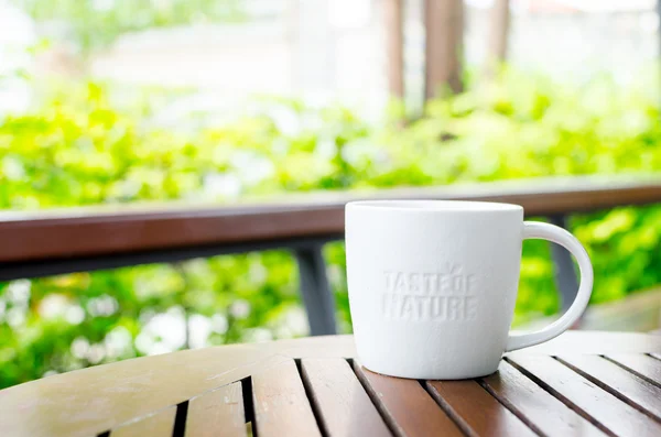 Taza de cerámica blanca con palabra de sello "Sabor de la naturaleza" en el café sh — Foto de Stock