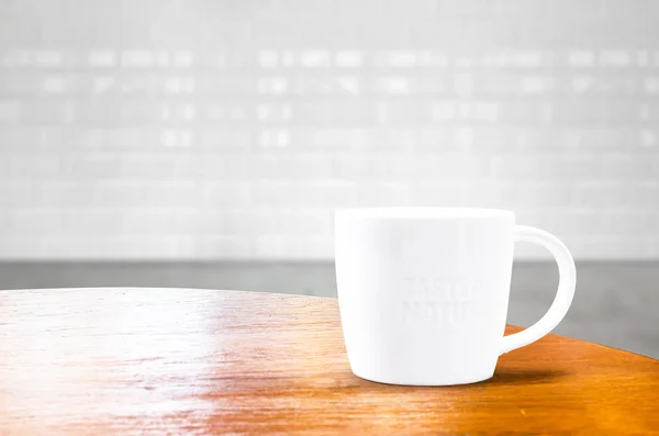 Wood round table with white mug at brick tile room — Stock Photo, Image