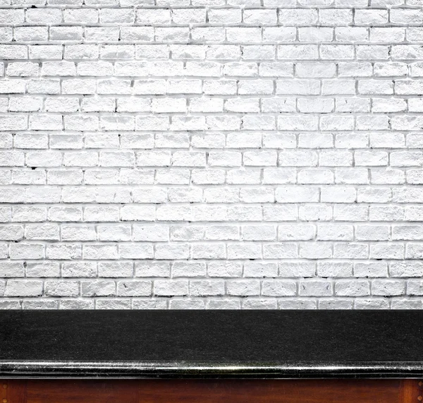 Стіл і біла цегляна стіна — стокове фото