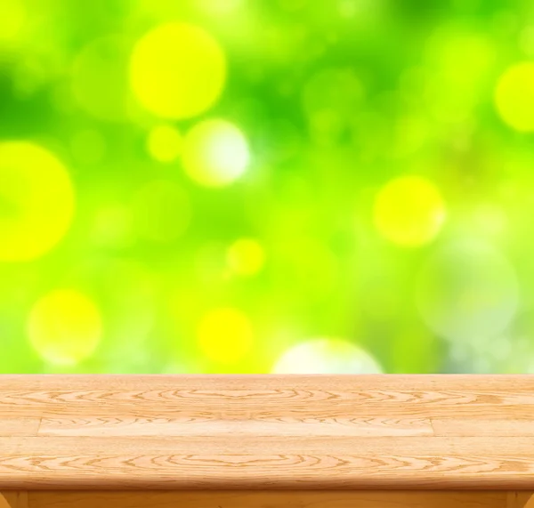 Wooden table with green bokeh — Stockfoto