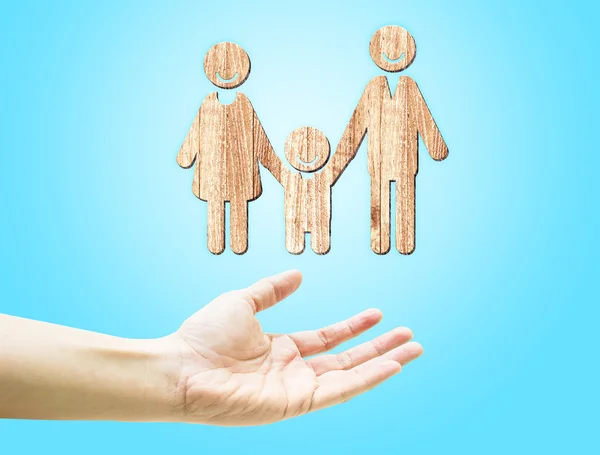 Open hand with wooden family icon — Stockfoto