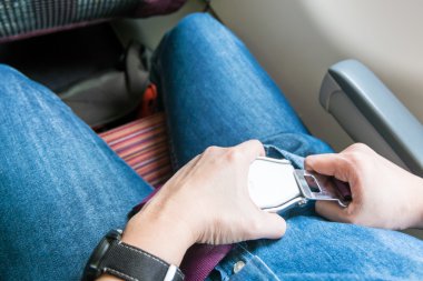 Hand fasten seat belt at seat