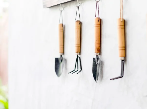 Garden tool hanging on concrete wall — Stockfoto