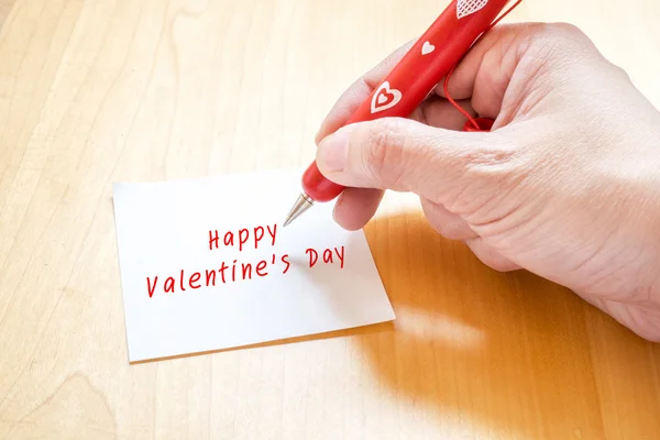 Dłoń trzymająca czerwony długopis z serca biały wzór, pisanie na puste — Zdjęcie stockowe