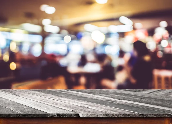 Tampo de mesa de madeira vazio com borrão de café com fundo bokeh — Fotografia de Stock