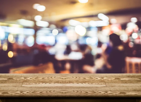 Tampo de mesa de madeira vazio com borrão de café com fundo bokeh — Fotografia de Stock