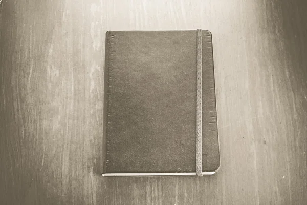 Color sepia vintage: Cuaderno de tapa dura antiguo con tira en madera — Foto de Stock