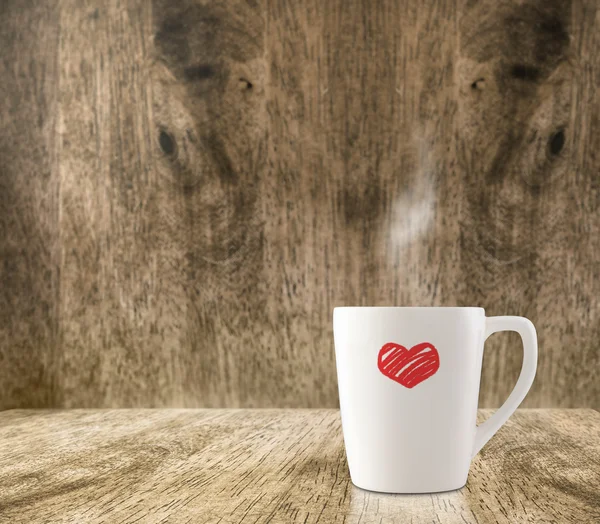 Kahve fincanı ahşap zemin üzerinde kırmızı kalpli — Stok fotoğraf