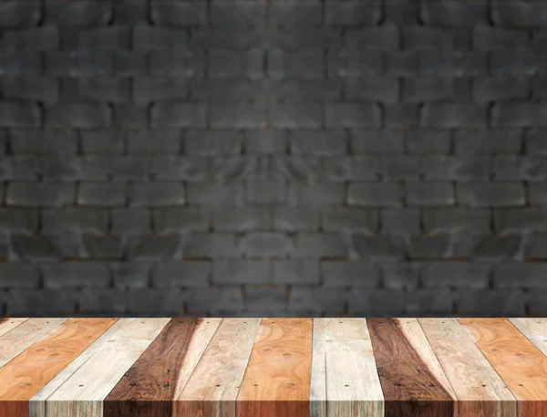 Mesa de madera tropical vacía y fondo borroso de pared de ladrillo negro — Foto de Stock