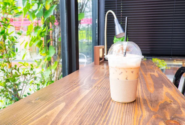 Ijs koffie op houten tafel naast venster — Stockfoto