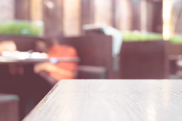 Mesa de madera vacía y cafetería borrosa — Foto de Stock