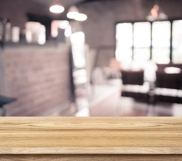 Mesa de madeira vazia e café desfocado — Fotografia de Stock