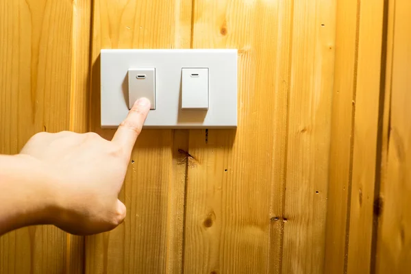 Finger press on light switch button — Stock Photo, Image