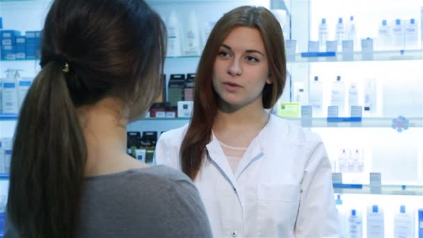 Фармацевт предлагает покупателю медикаменты — стоковое видео