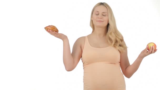 Mujer embarazada muestra manzana y pastel — Vídeos de Stock