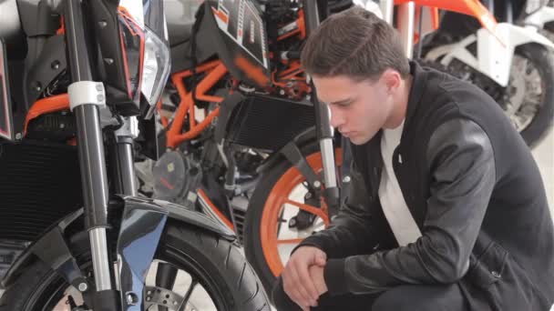 Το κλείσιμο ενός νεαρού πελάτη εξετάζει τη μοτοσικλέτα — Αρχείο Βίντεο