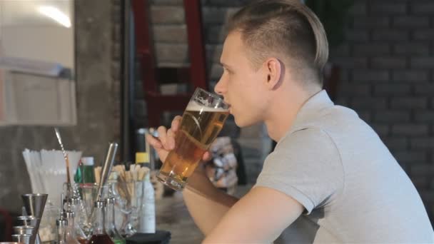 Man smiles after sip of beer — ストック動画