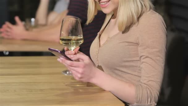 Close up of a young woman uses smartphone at the bar — Αρχείο Βίντεο