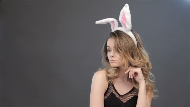 Menina mostra surpresa com orelhas de coelho na cabeça — Vídeo de Stock