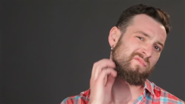 Молодой парень чешет бороду — стоковое видео