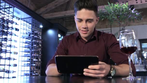 Man maakt gebruik van een tablet in het restaurant — Stockvideo