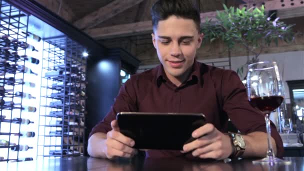 Человек кладет планшет на стол в ресторане — стоковое видео