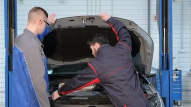 İki mekanik araba servisi araba kukuleta açın
